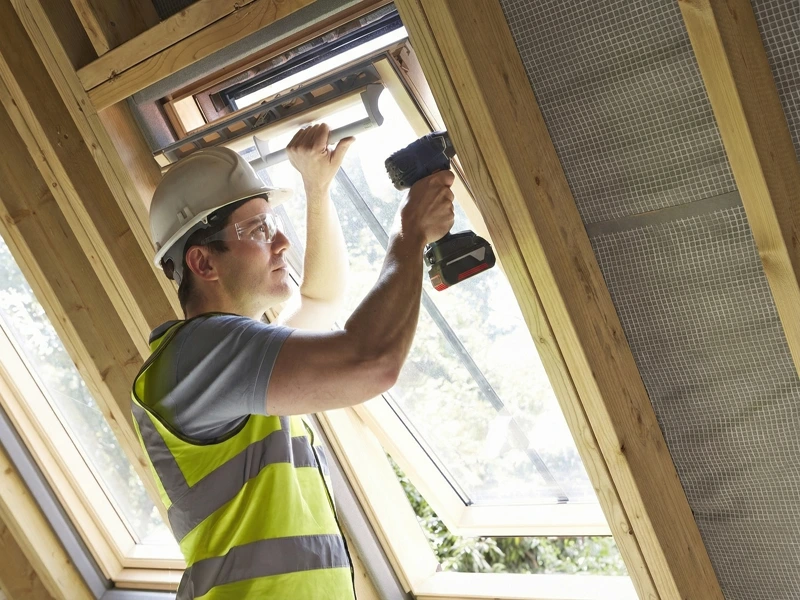 Carpenter fitting a roof window as part of on-site carpentry work