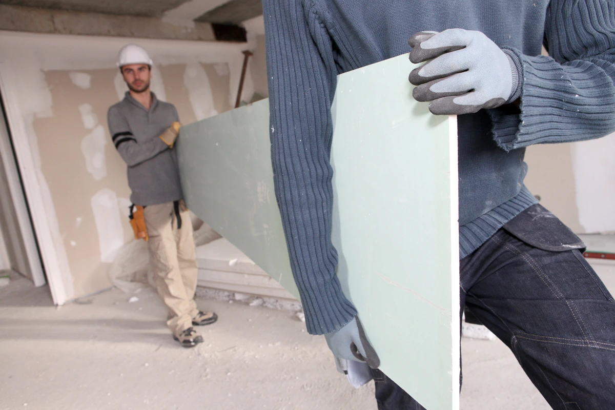 Two Dry Lining Fixers Carrying Board